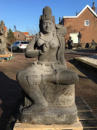 Large Devi Tara statue in Indonesian lavastone, seated full front view outdoors on a pallet