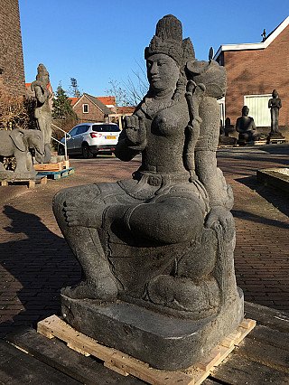 Devi Tara statue in Indonesian lavastone, seated three-quarter view with tall crown