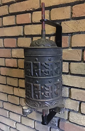 Nepali praying wheel P-023 mounted on wall bracket, with raised script and wooden shaft