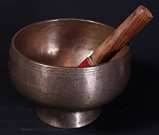Antike nepalesische Klangschale aus Bronze mit Holzklöppel, schräg von vorn