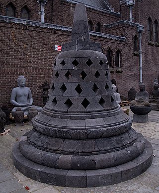 Lavastenen stupa met kegelvormige top, schuin van voren gefotografeerd in buitenopstelling
