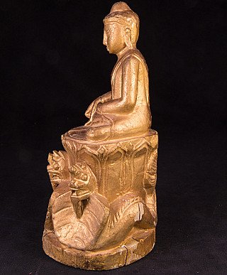 Burmese wooden Buddha statue, left side profile in seated posture on a tall base