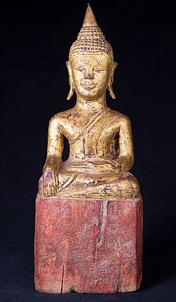 Antique Thai wooden Buddha statue seated in bhumisparsha mudra, full-front view on red base