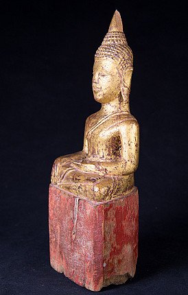 Thai wooden Buddha statue seated, three-quarter left view with red pedestal base