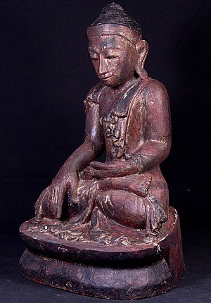 Antique wooden Buddha statue from Myanmar, seated in bhumisparsha mudra, three-quarter left view