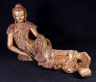 Liggende houten Boeddha uit Myanmar met vergulding en rood decor, schuin van voren met benen naar rechts