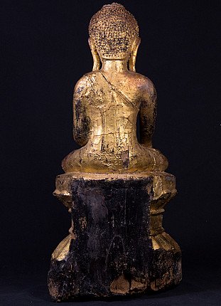 Antique Burmese wooden Buddha statue, rear view showing aged surface cracks