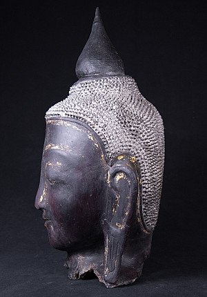 Boeddhakop uit Burma in zijaanzicht, met lange oorlel en textuur van krulhaar