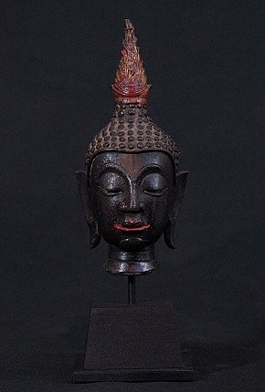 Thai bronze Buddha head on a metal stand, full front view with closed eyes and flame finial