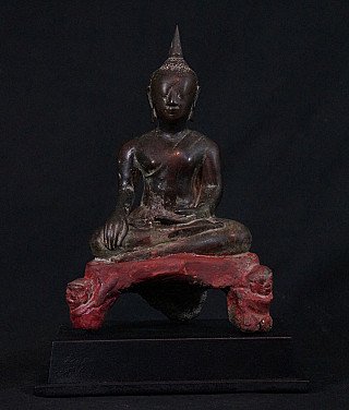 Thai bronze Buddha statue seated in bhumisparsha mudra, full front view on red base