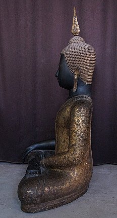 Antique Thai bronze Buddha statue in left side profile with flame finial