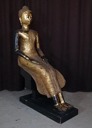 Thai bronze Buddha statue seated on a plinth, three-quarter left view