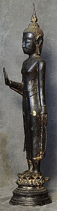 Thai bronze Buddha statue standing, left side profile showing raised hand in Abhaya mudra