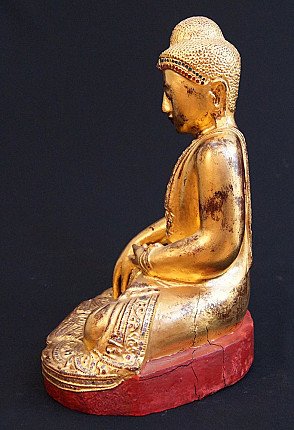 Wooden Buddha statue from Myanmar, seated on red-lacquered base, right side profile
