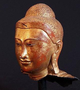 Detailrijk driekwartaanzicht van bronzen Boeddhahoofd, gezicht en haarrand