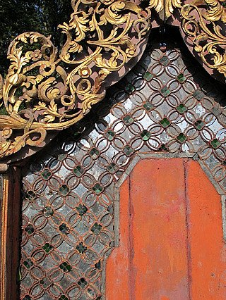 Close-up of the patterned field and arched niche on the Shan wall panel, showing wear